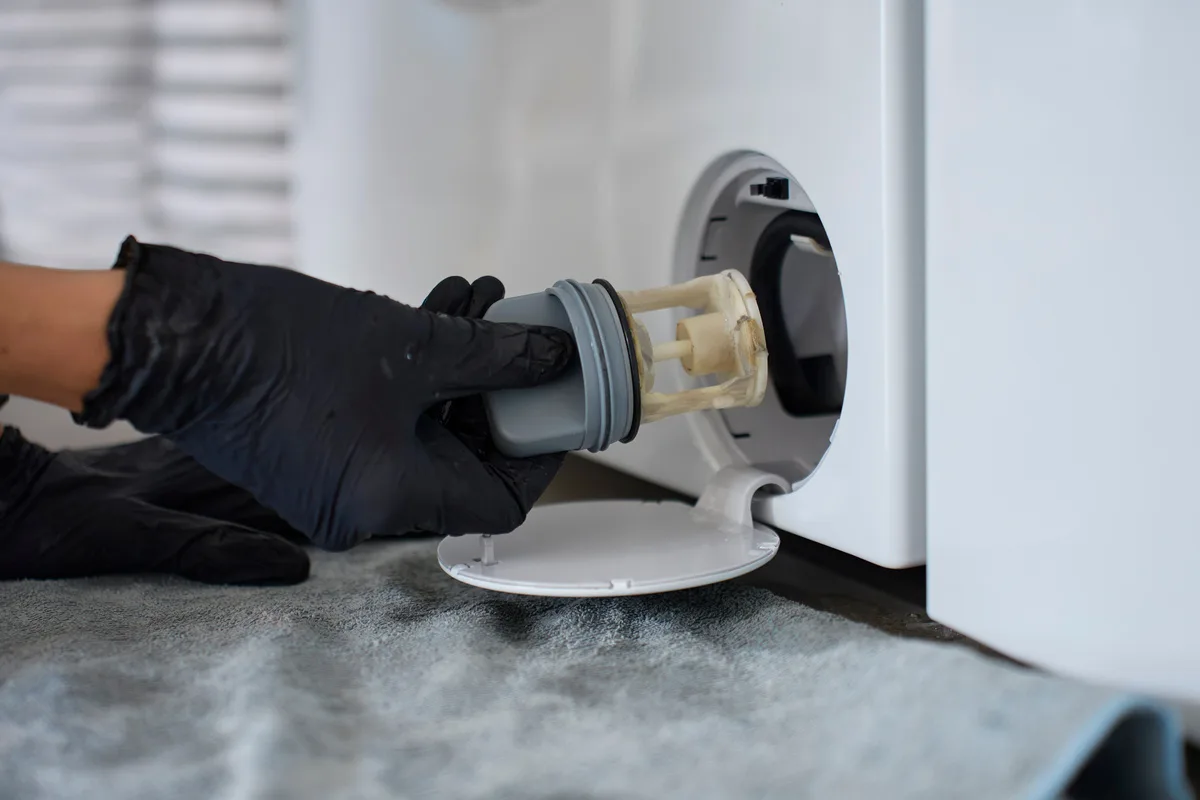 Monteurs openen dit kleine klepje onderaan je wasmachine als eerste – de meeste mensen hebben het nog nooit aangeraakt