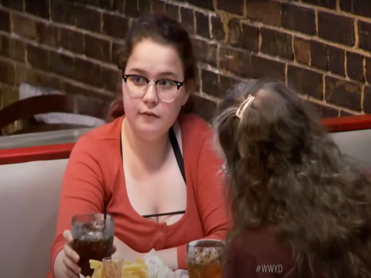 Alleinstehende Mutter und Kinder im Restaurant bemerken den hinter ihnen sitzenden Mann nicht