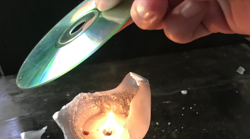 Ella está sosteniendo un viejo CD sobre una vela y está surgiendo algo hermoso